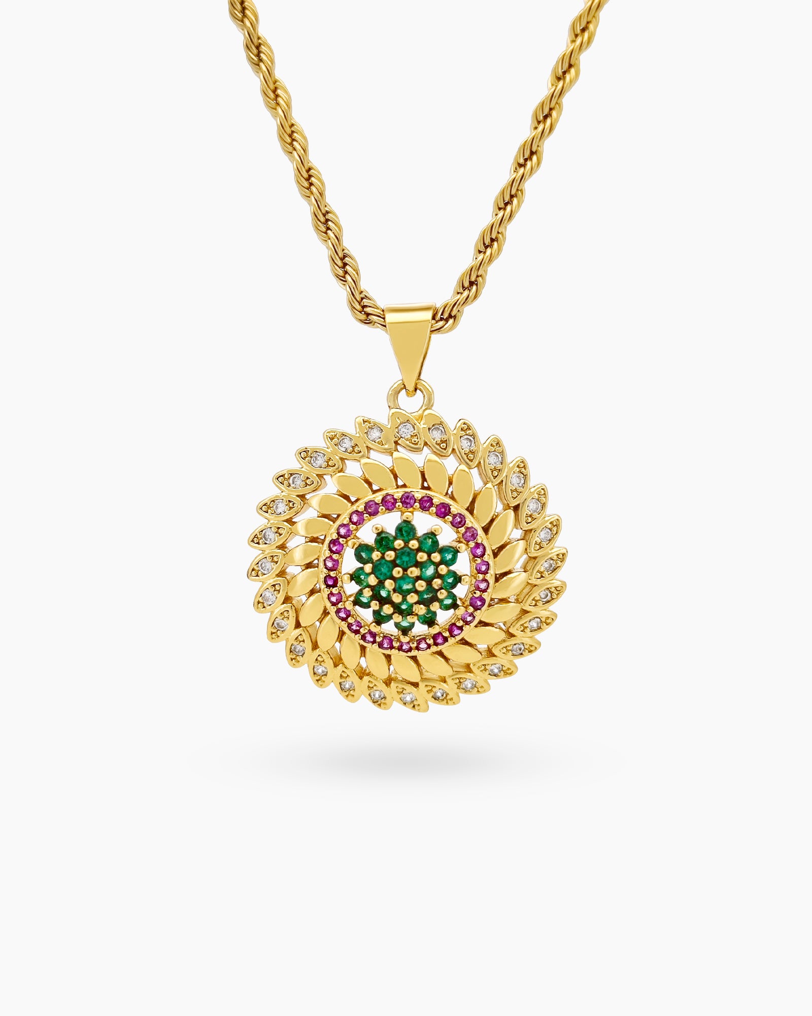 A necklace with a detailed gold-tone rope chain and a radiant circular pendant with green and pink zircons
