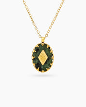 A necklace with a green african pine stone pendant in a textured gold-toned bezel with a diamond motif