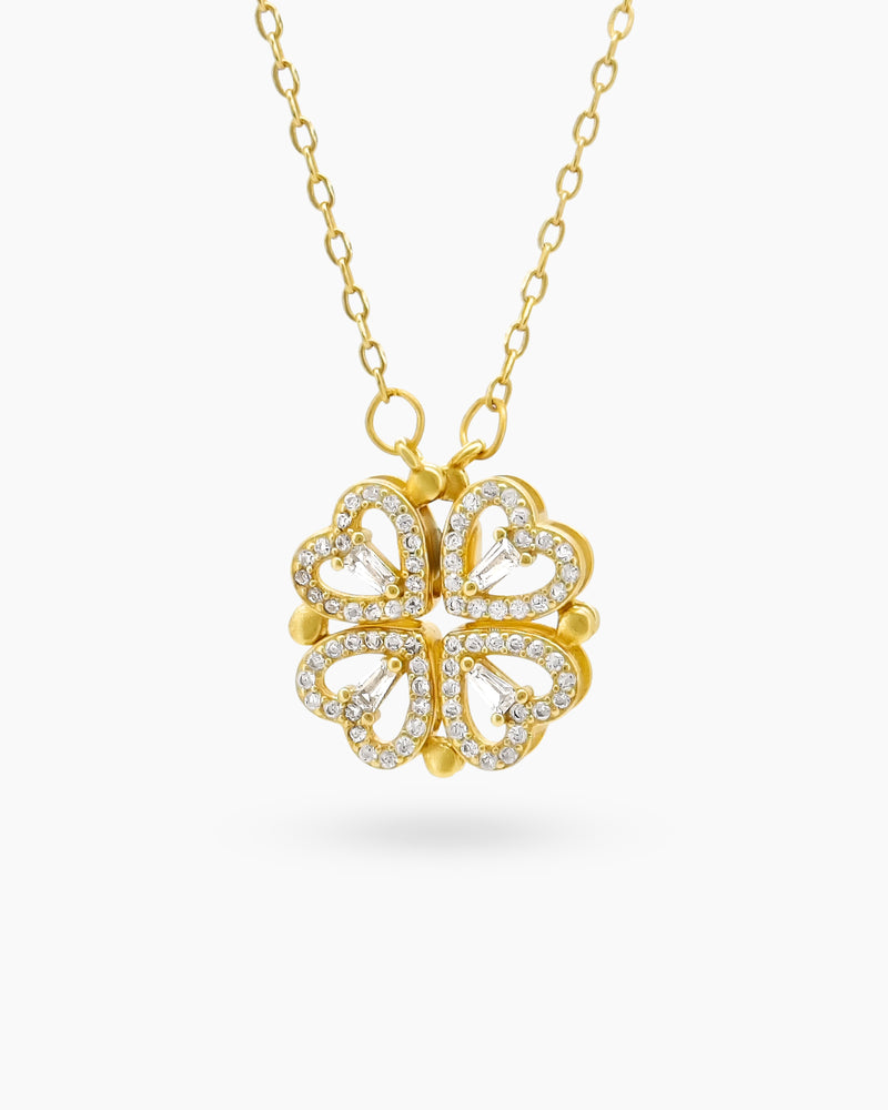 A gold necklace with a clover-inspired pendant of four pavé-outlined hearts that opens up