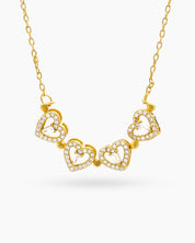 A gold necklace with a clover-inspired pendant of four pavé-outlined hearts that opens up