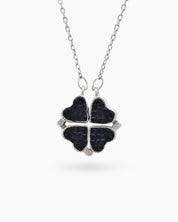 A necklace with a double-faceted finish in vivid ruby red and deep navy on a clover-shaped pendant