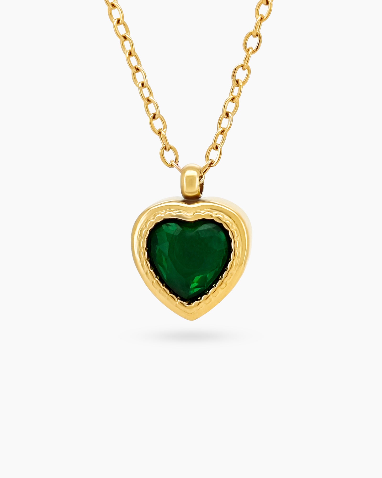 A green necklace with a heart-shaped zircon centerpiece in an antique-inspired gold bezel