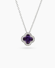 A purple necklace with a clover pendant outlined in pavé zircons and a faceted four-petal center stone