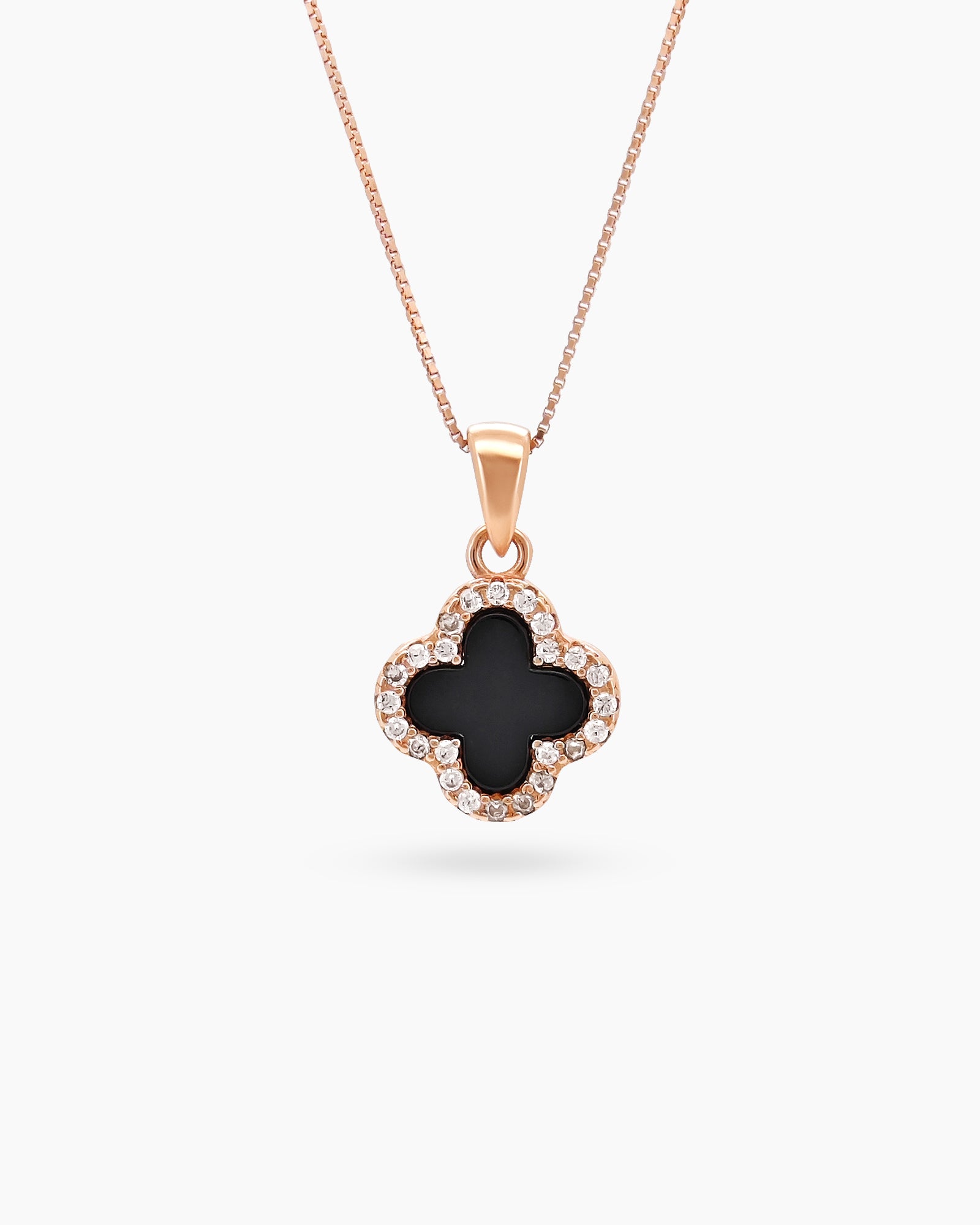 A rose gold necklace with a reversible four-leaf clover pendant, with black zircon on the other side