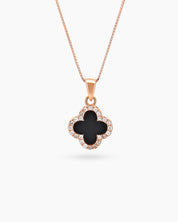 A rose gold necklace with a reversible four-leaf clover pendant, with black zircon on the other side