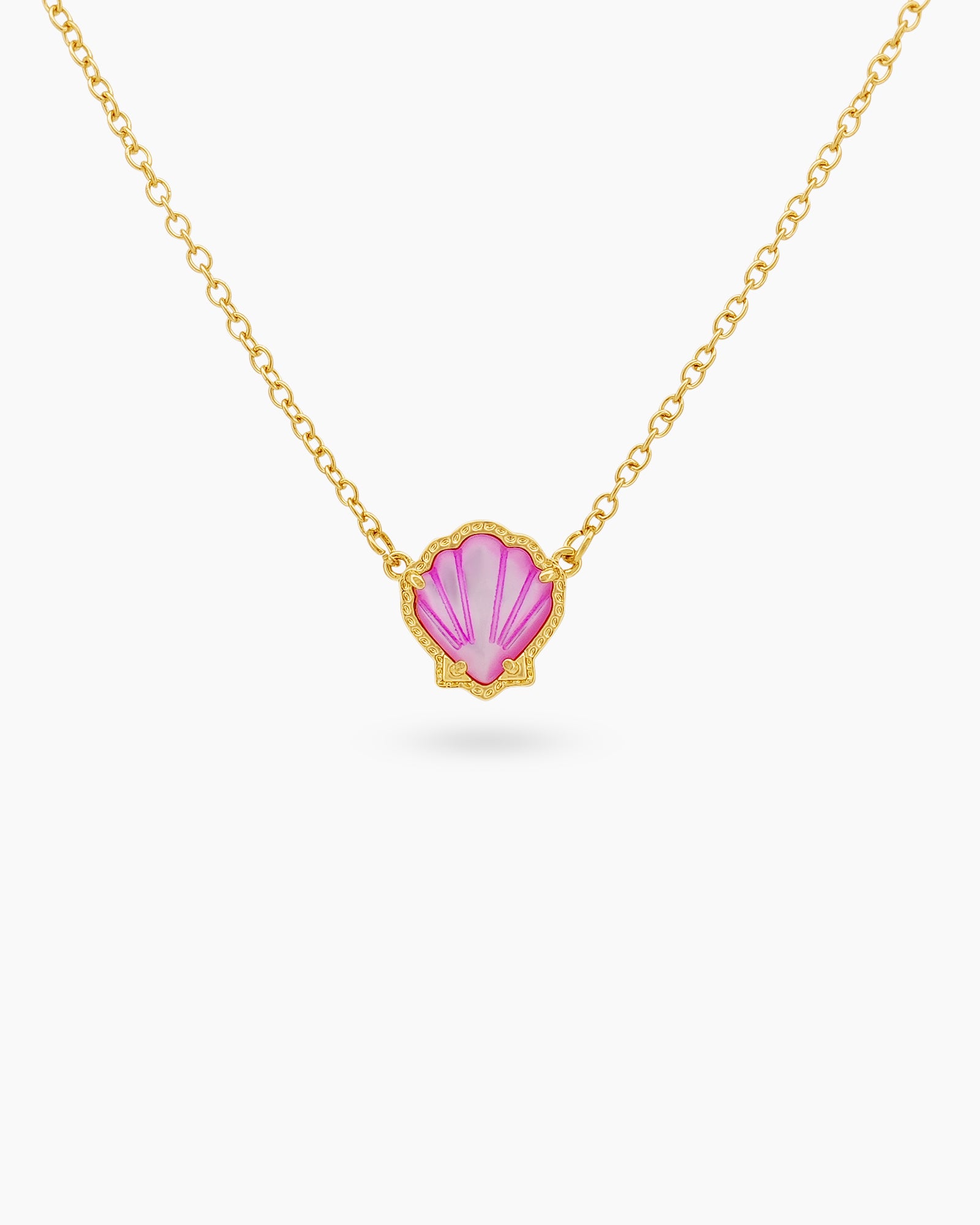 A pink necklace with a hand-engraved resin shell pendant in a fine gold-tone bezel on a dainty chain