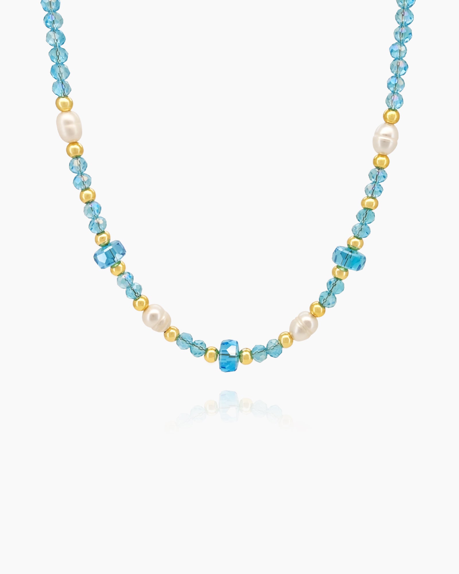A necklace with a strand of translucent aqua blue beads, accented with soft white pearls and tiny gold spacers