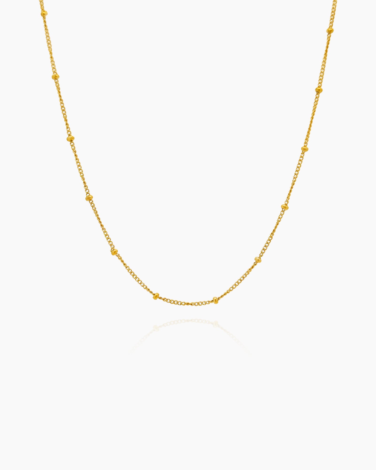A fine gold-tone chain necklace accented with evenly spaced bead-like stations for subtle texture