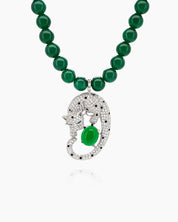 A necklace with a full strand of deep green jade beads and a striking silver-tone panther pendant
