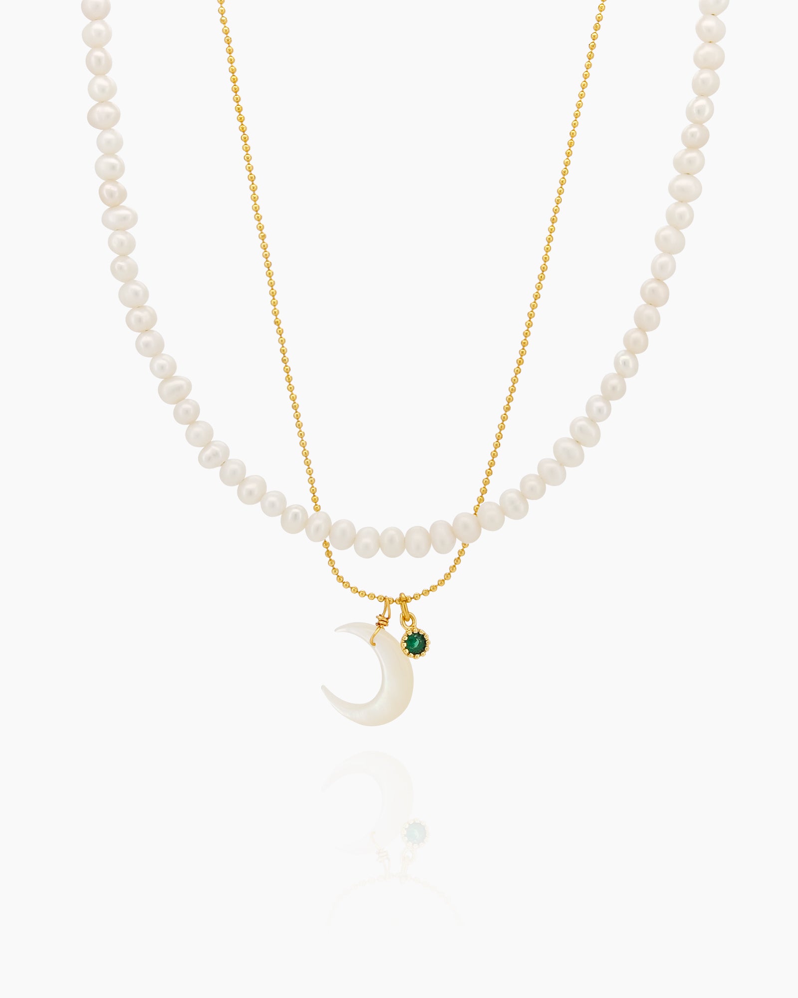 A double-layer necklace with lustrous freshwater pearls and a glowing mother-of-pearl crescent moon charm