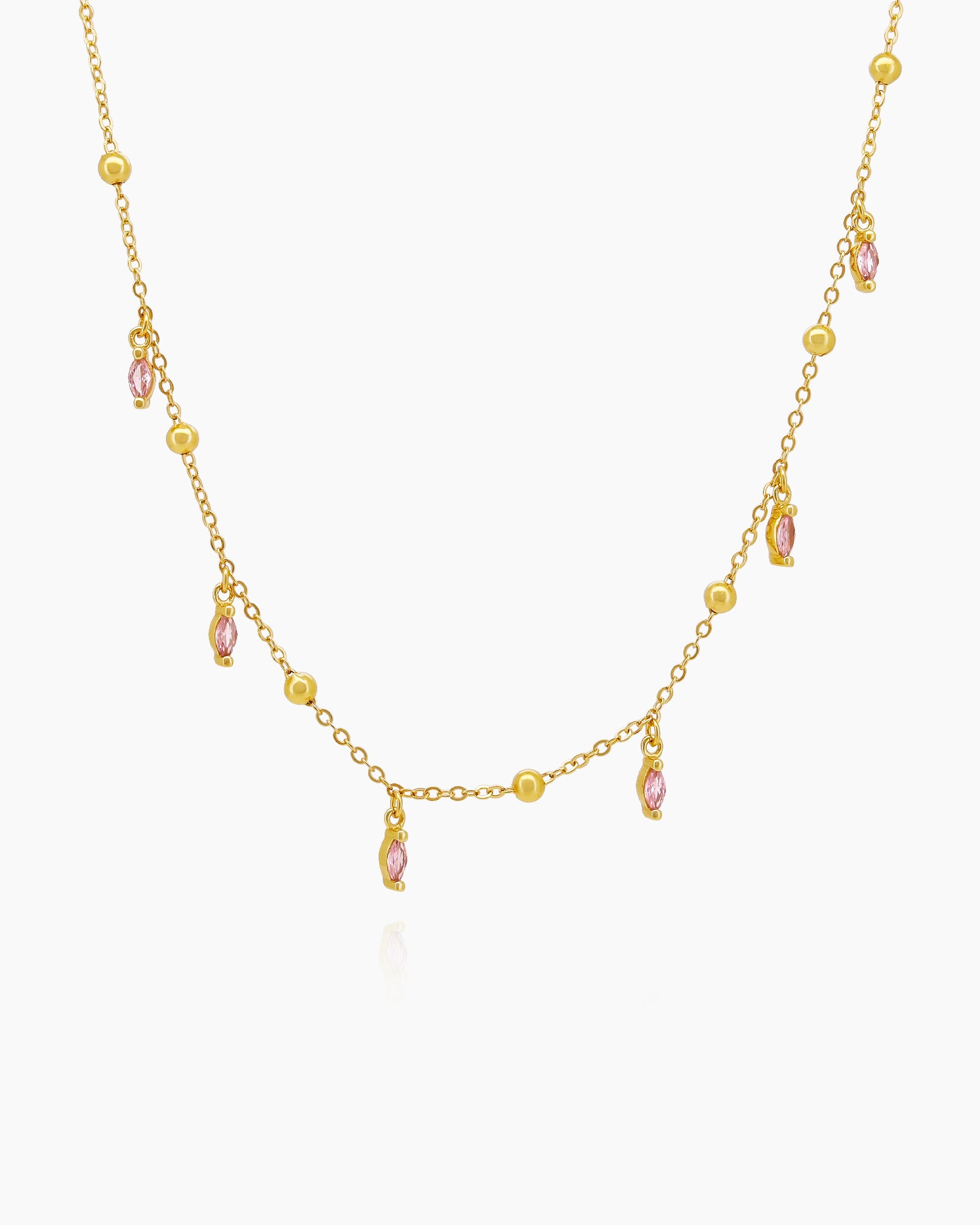A choker with a delicate chain dotted with polished golden beads and dainty pink marquise-cut crystal drops