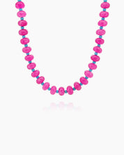 A beaded necklace with glossy fuchsia-toned quartz beads and petite turquoise-blue spacers