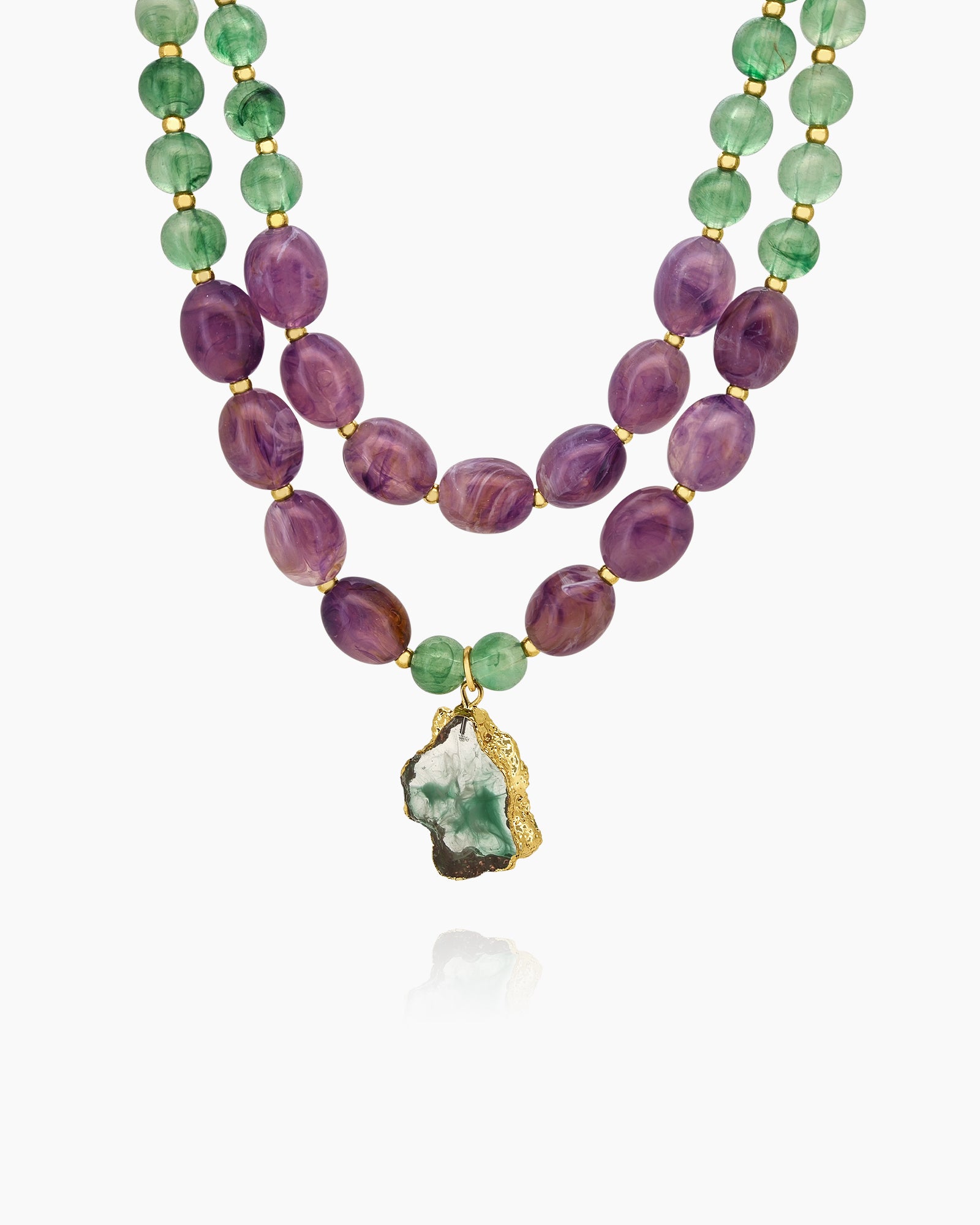 A necklace with dual strands of polished green and violet beads and a resin stone pendant