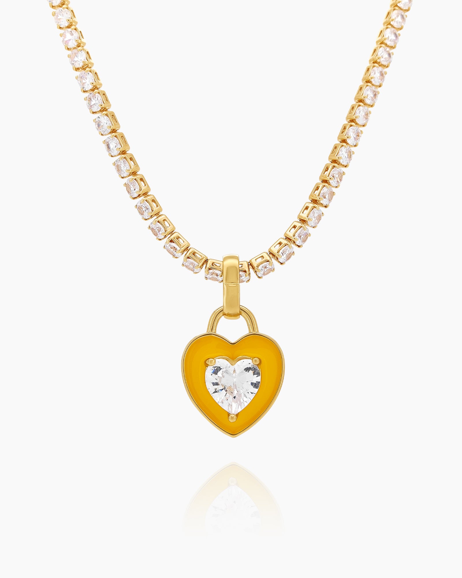 A yellow tennis necklace with a full strand of zircon stones and an enamel heart charm with a center stone