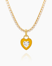 A yellow tennis necklace with a full strand of zircon stones and an enamel heart charm with a center stone