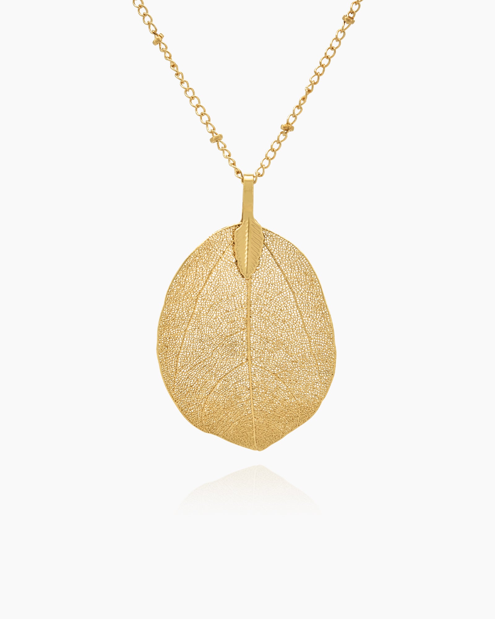 A gold necklace with a delicate leaf pendant featuring intricate vein patterns on a slim, textured chain