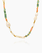 A beaded necklace with freshwater pearls, coral-hued cylinders, and sea-green faceted agate beads