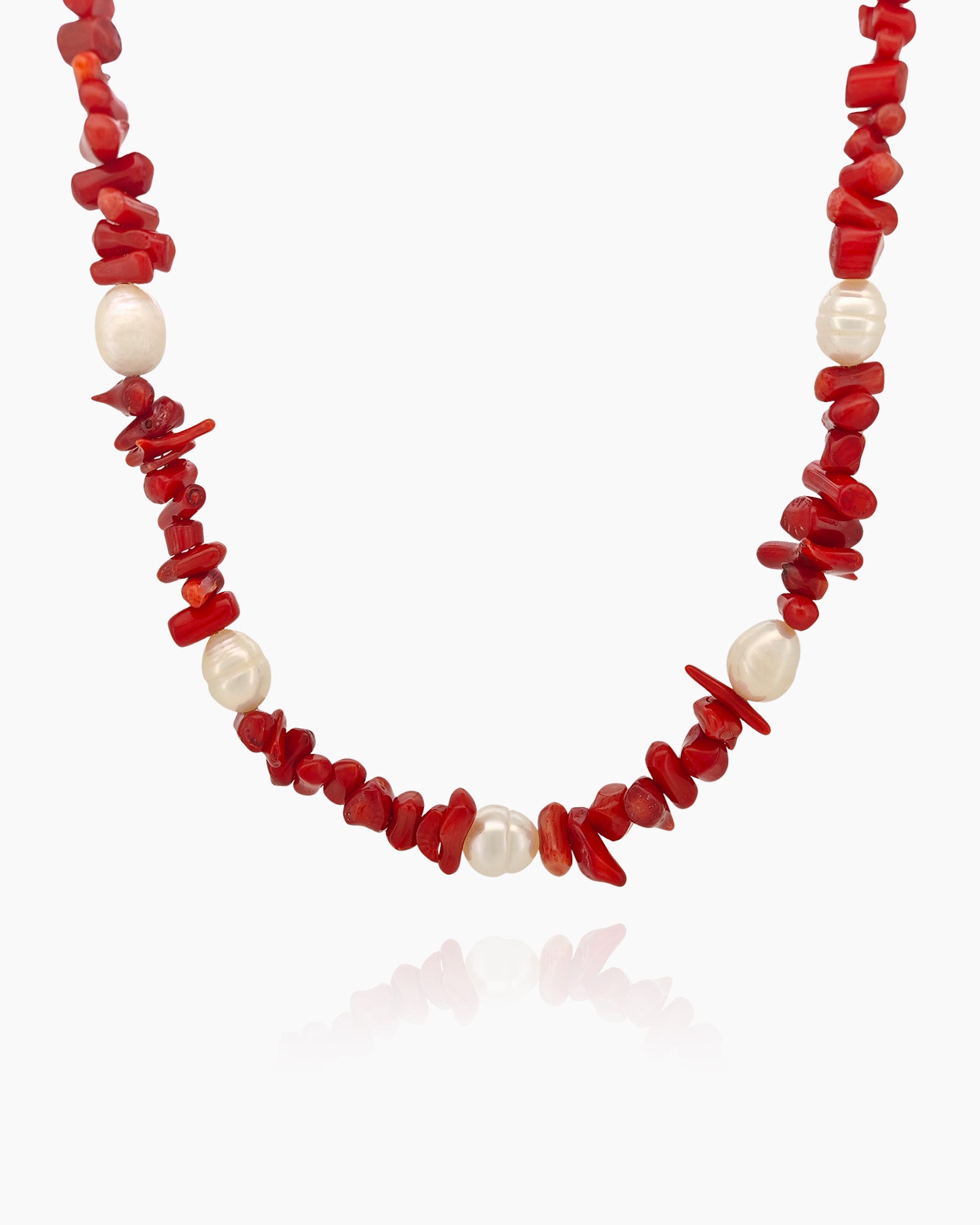 A necklace of vibrant coral stones and glowing freshwater pearls, finished with gold accents