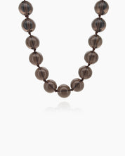 A '90s safari-style necklace with smooth, polished brown stones for a grounded, earthy charm