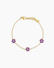 A purple bracelet with a delicate gold-tone chain adorned with a glossy enamel daisy