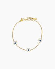 A white bracelet with a delicate gold-tone chain adorned with a glossy enamel daisy