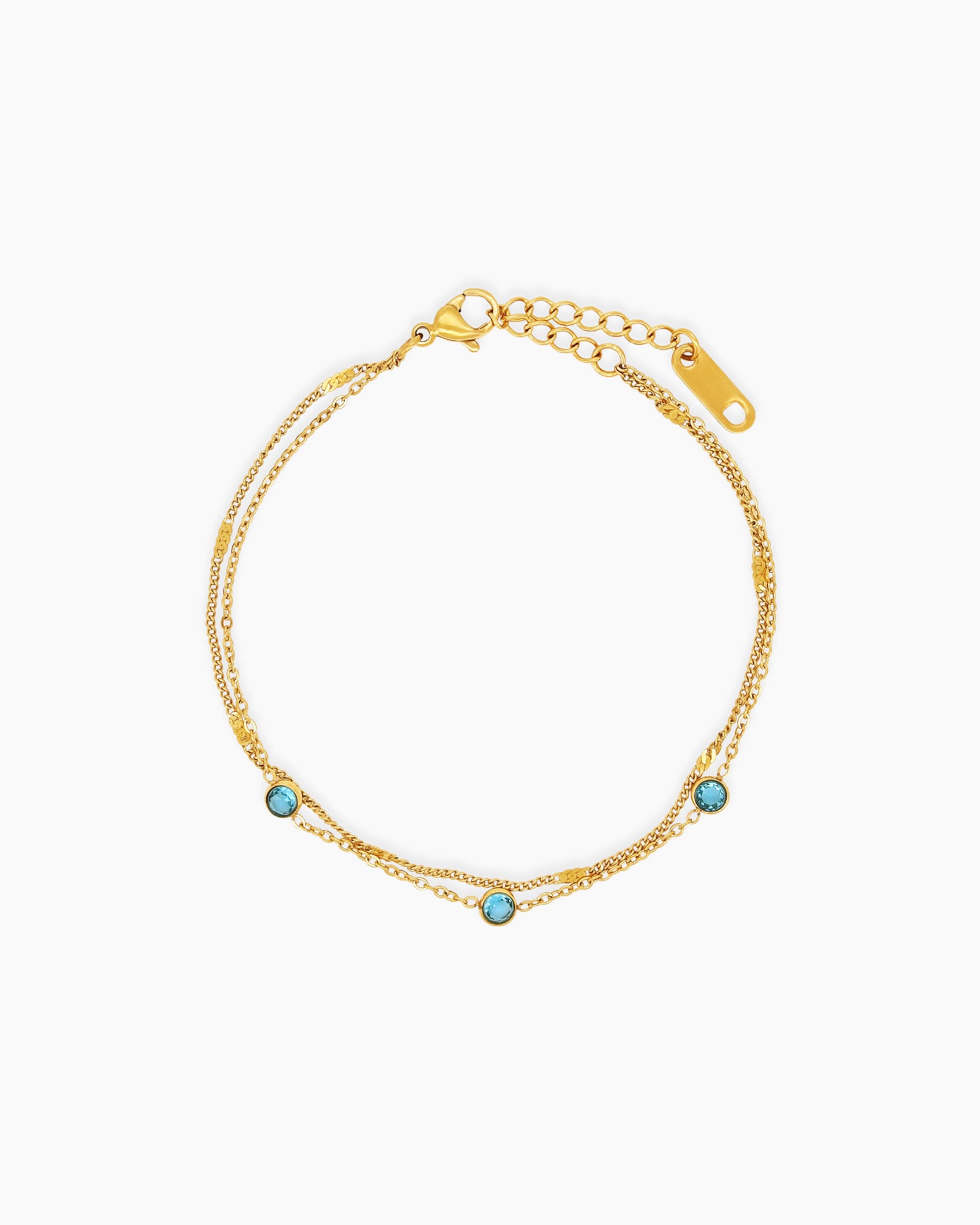A bracelet with two fine gold-tone chains dotted with three soft, glimmering sky blue zircon stones