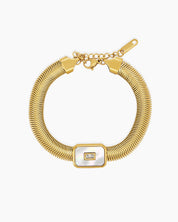 A white bracelet with a bold gold-tone snake chain and a rectangular mother-of-pearl charm