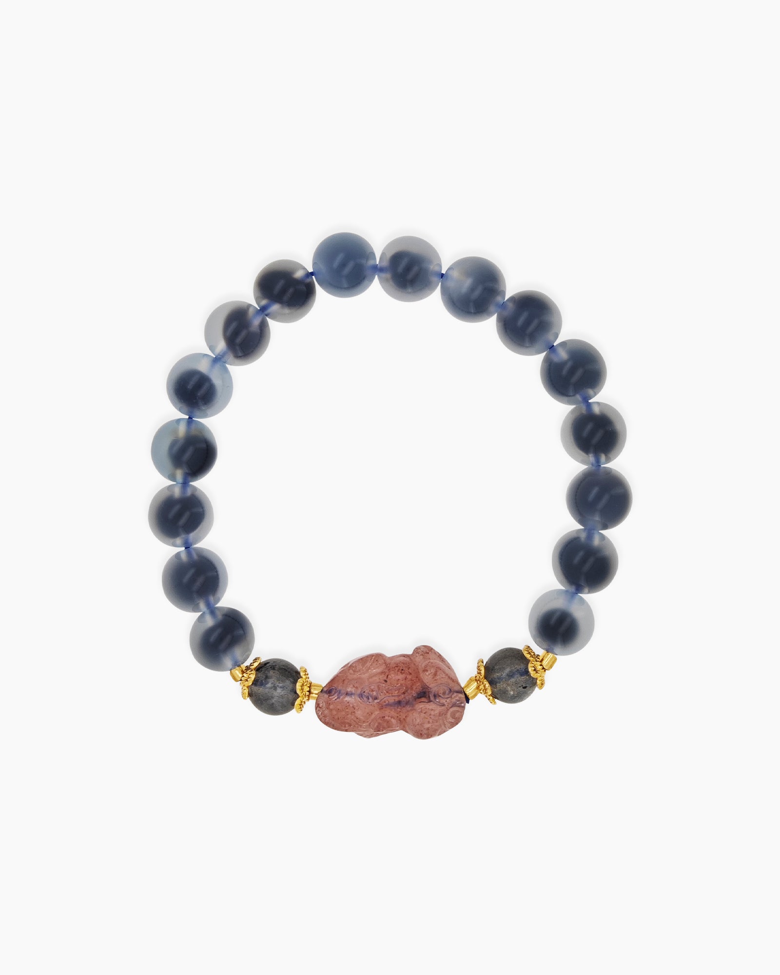 A bracelet of smooth blue agate stones with a central carved pink charm and golden accents