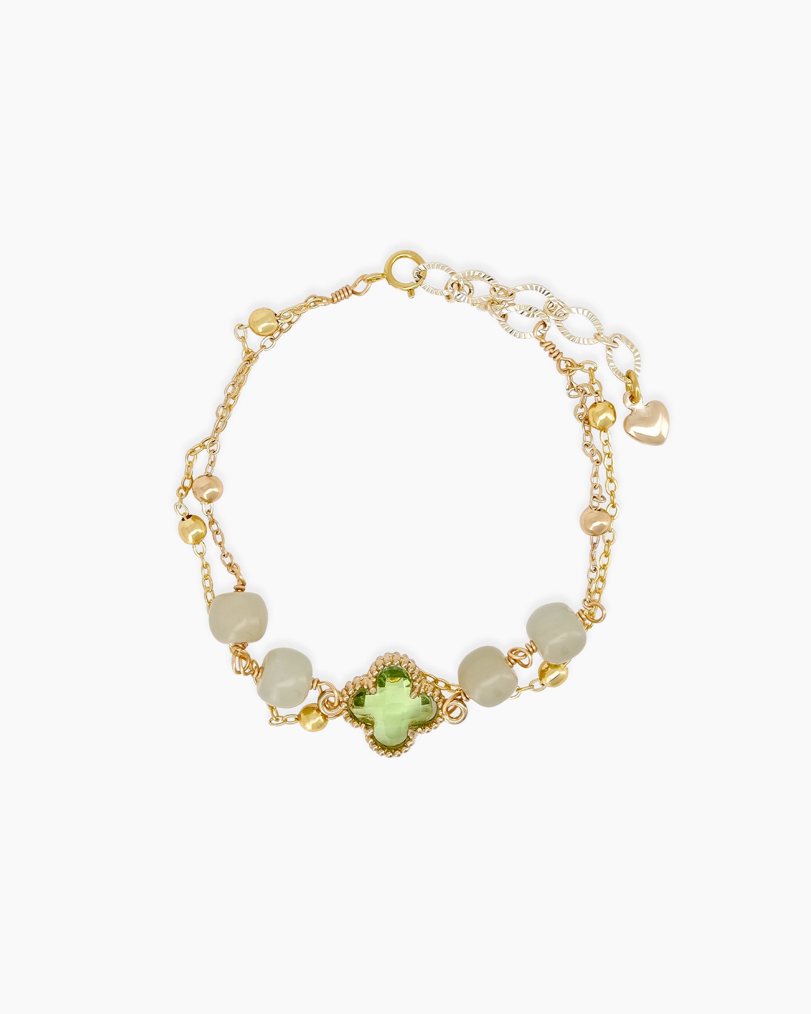 A bracelet with a green clover-like jade stone at its heart, with soft jade beads and golden accents
