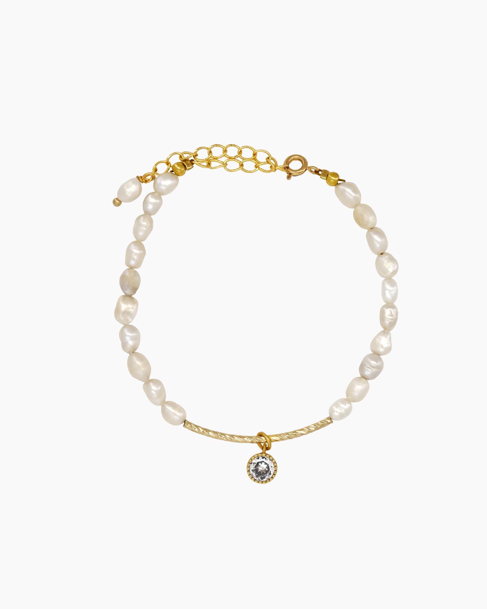 A bracelet of lustrous freshwater pearls with a sleek, textured gold arc and a single glinting zircon charm