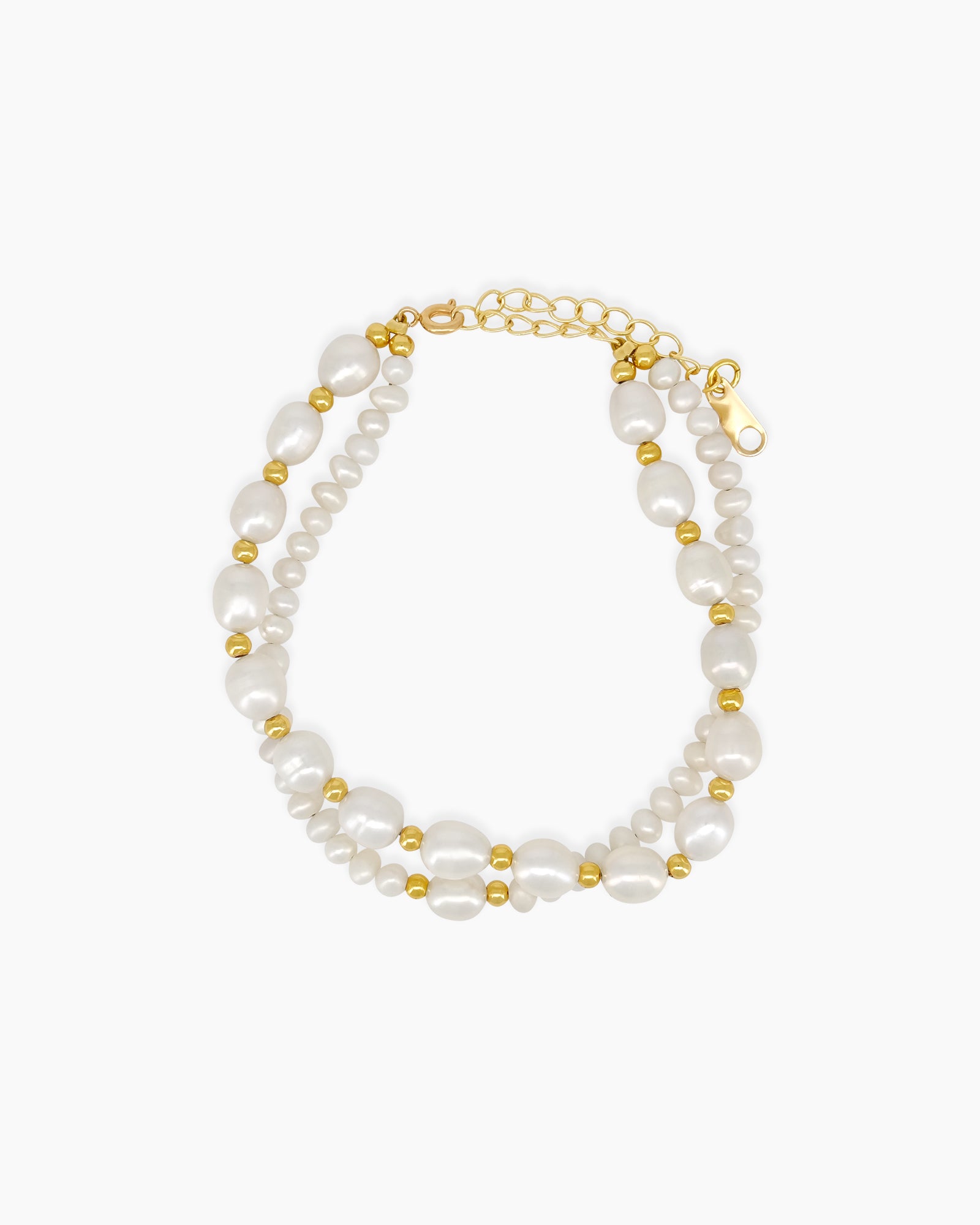 A bracelet with two rows of freshwater pearls in contrasting sizes, interspersed with golden beads