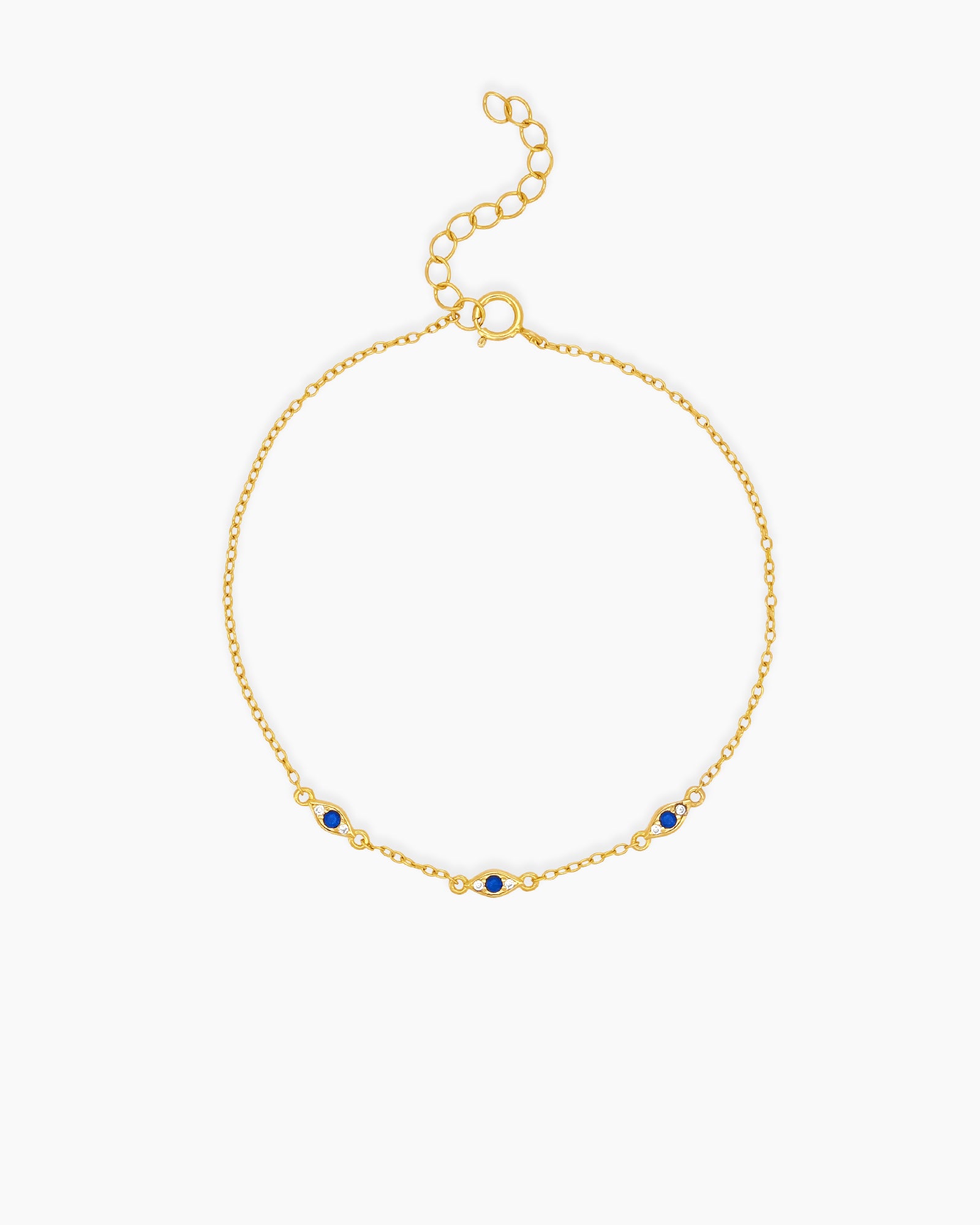 An understated bracelet with three dainty evil eye charms and deep blue zircons on a fine gold chain