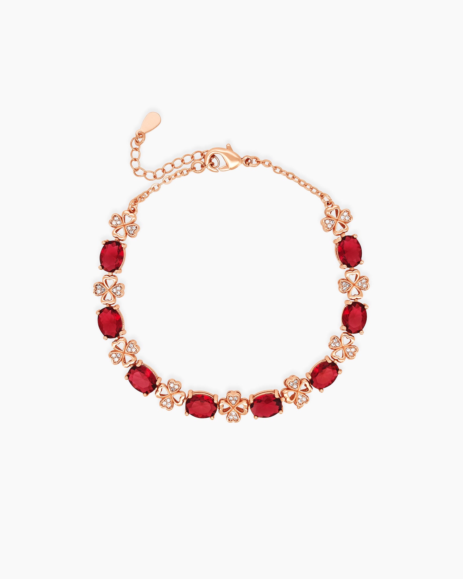 A rose gold bracelet with radiant red oval-cut stones and delicate, sparkling clover-shaped connectors