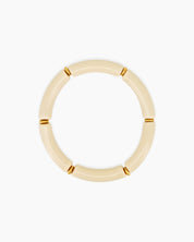 A playful beige bangle with smooth, curved acrylic segments and delicate golden connectors