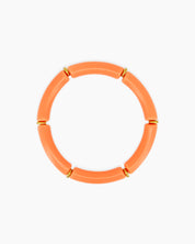 A playful coral bangle with smooth, curved acrylic segments and delicate golden connectors