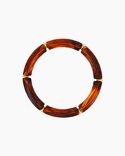 A playful honey bangle with smooth, curved acrylic segments and delicate golden connectors