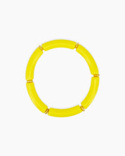 A playful lemon bangle with smooth, curved acrylic segments and delicate golden connectors