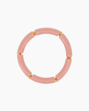 A playful pink bangle with smooth, curved acrylic segments and delicate golden connectors