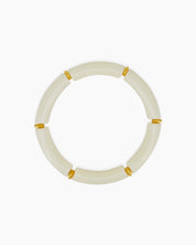 A playful white bangle with smooth, curved acrylic segments and delicate golden connectors