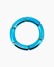A radiant blue bangle with a sleek tubular silhouette and a high-shine metallic finish