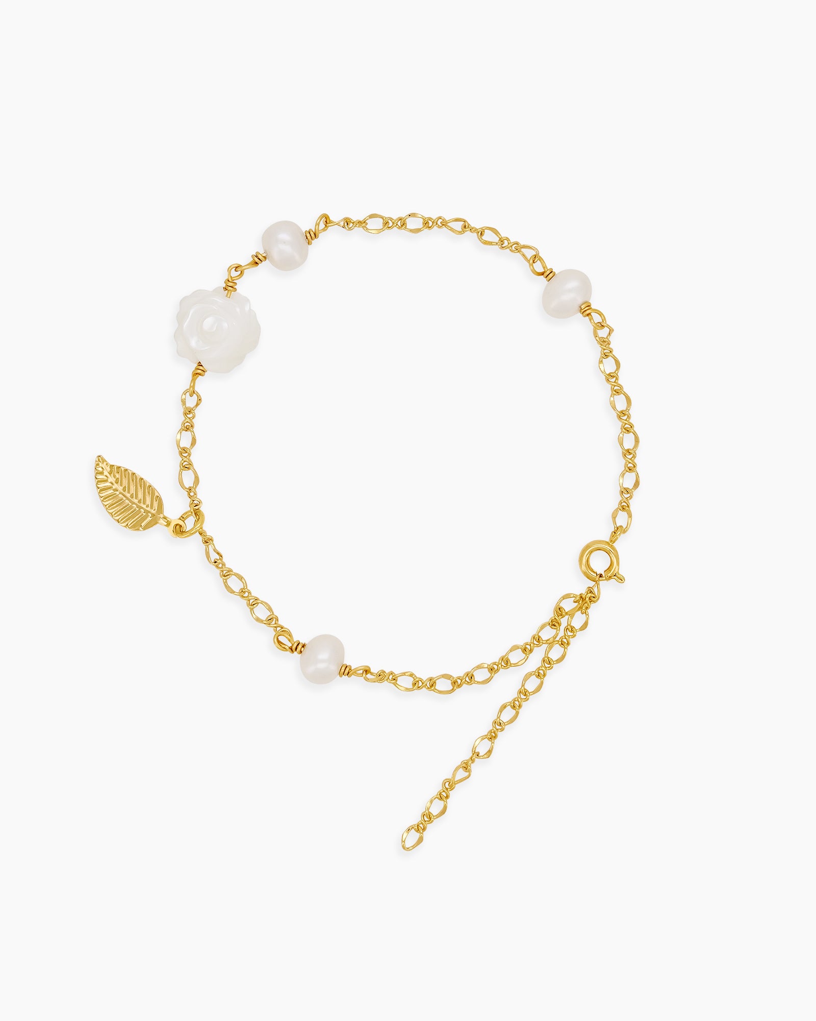 A bracelet with a finely sculpted white rose centerpiece, framed by freshwater pearls and a golden leaf accent