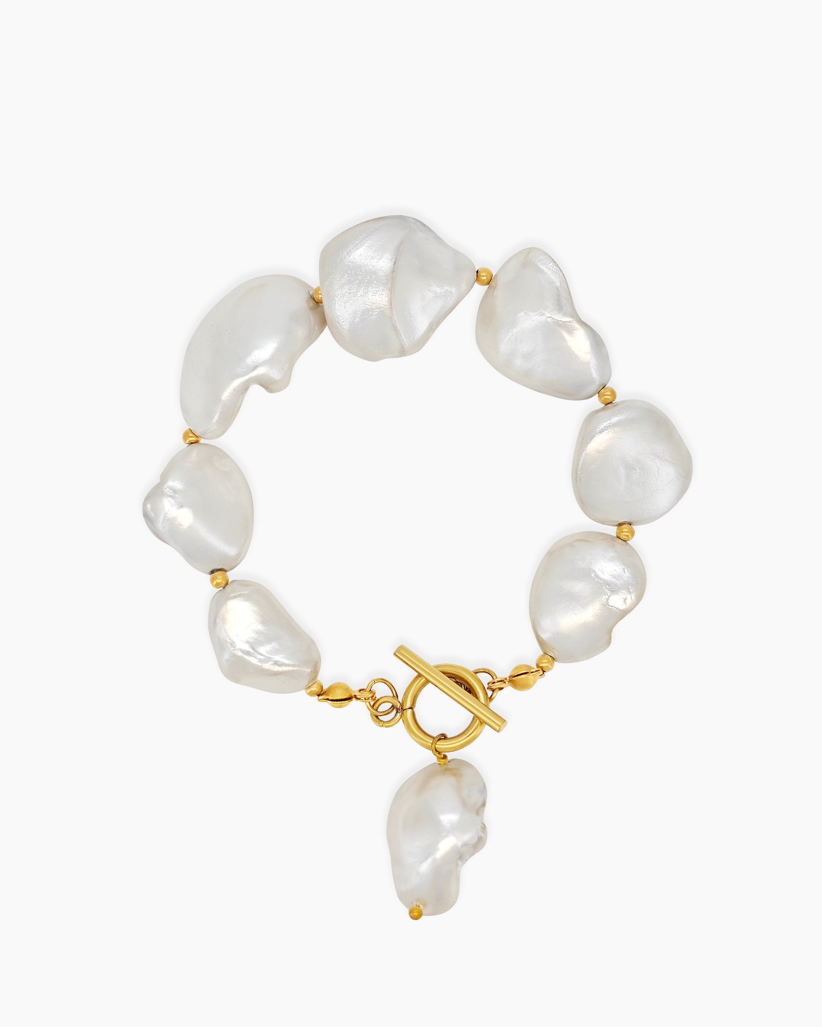 A bracelet of shimmering baroque pearls nestled between dainty gold beads, with a bold T-bar toggle clasp