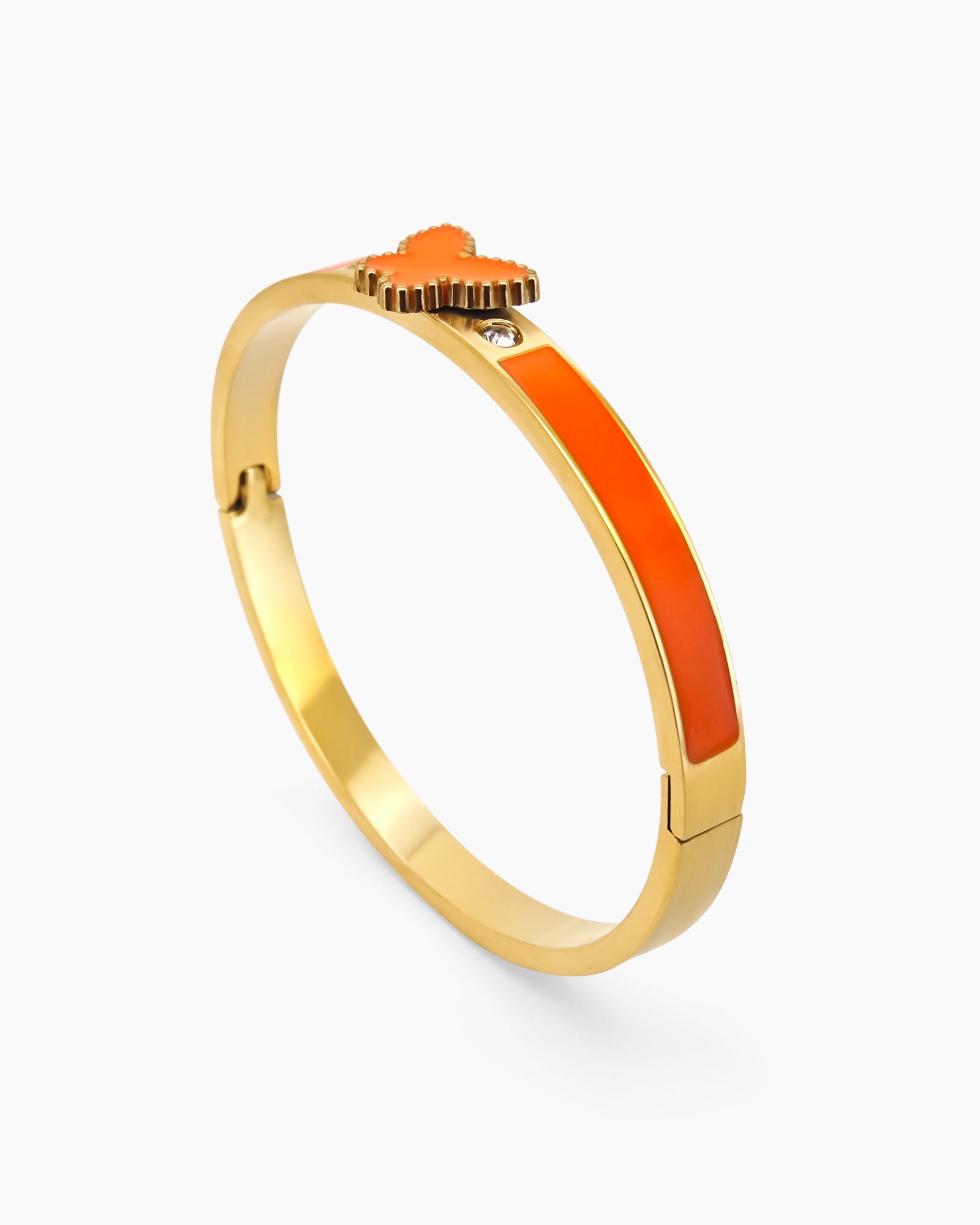 An orange hinged bangle with a sleek gold-tone design, vibrant enamel band, and a butterfly centerpiece