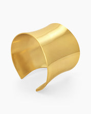 A gold open cuff with a wide, clean silhouette and a mirror-like finish for a minimalist, high-impact look