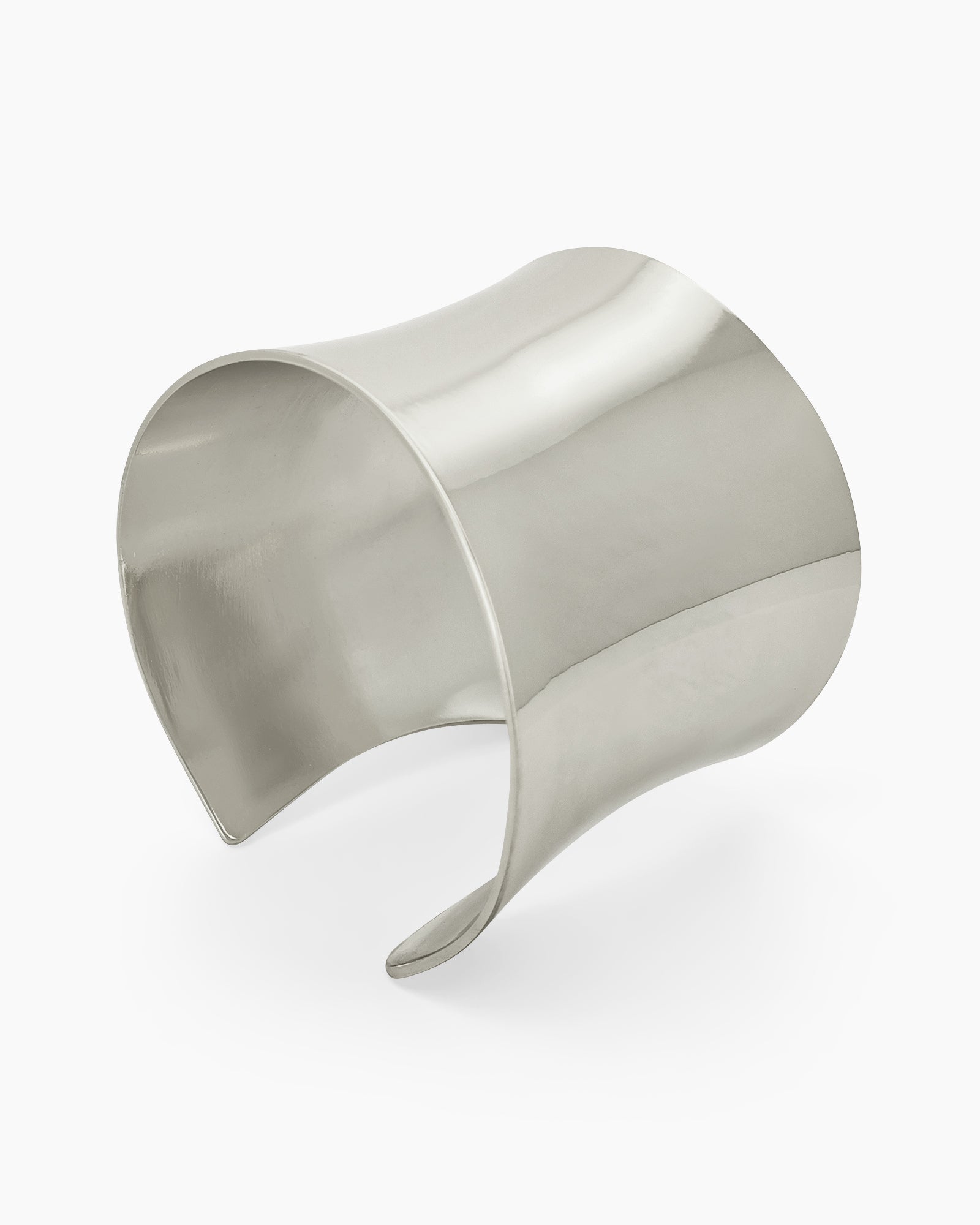 A silver open cuff with a wide, clean silhouette and a mirror-like finish for a minimalist, high-impact look