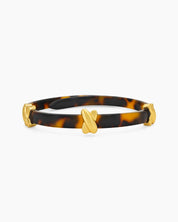 A double-wrapped bangle in high-gloss acrylic with a tortoiseshell effect and polished cross details