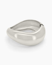 A silver hinged bangle with smooth curves and a fluid, wave-like silhouette for a minimalist focus