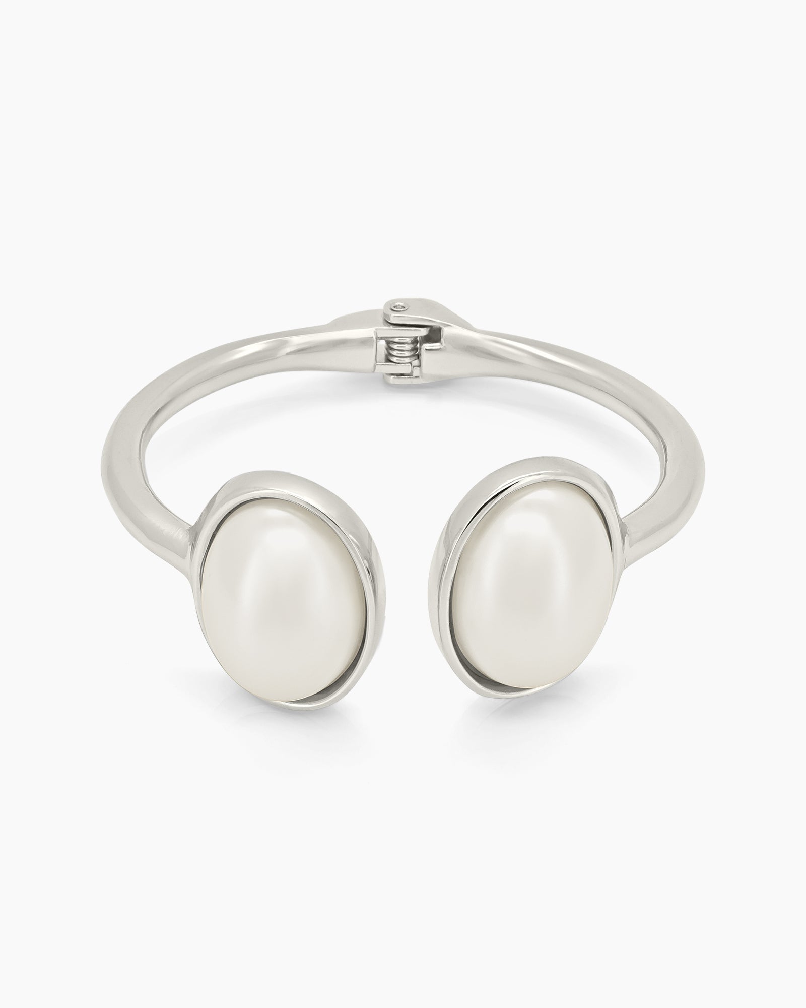 A polished silver cuff with two oversized faux pearls in a glossy frame and a secure hinge closure