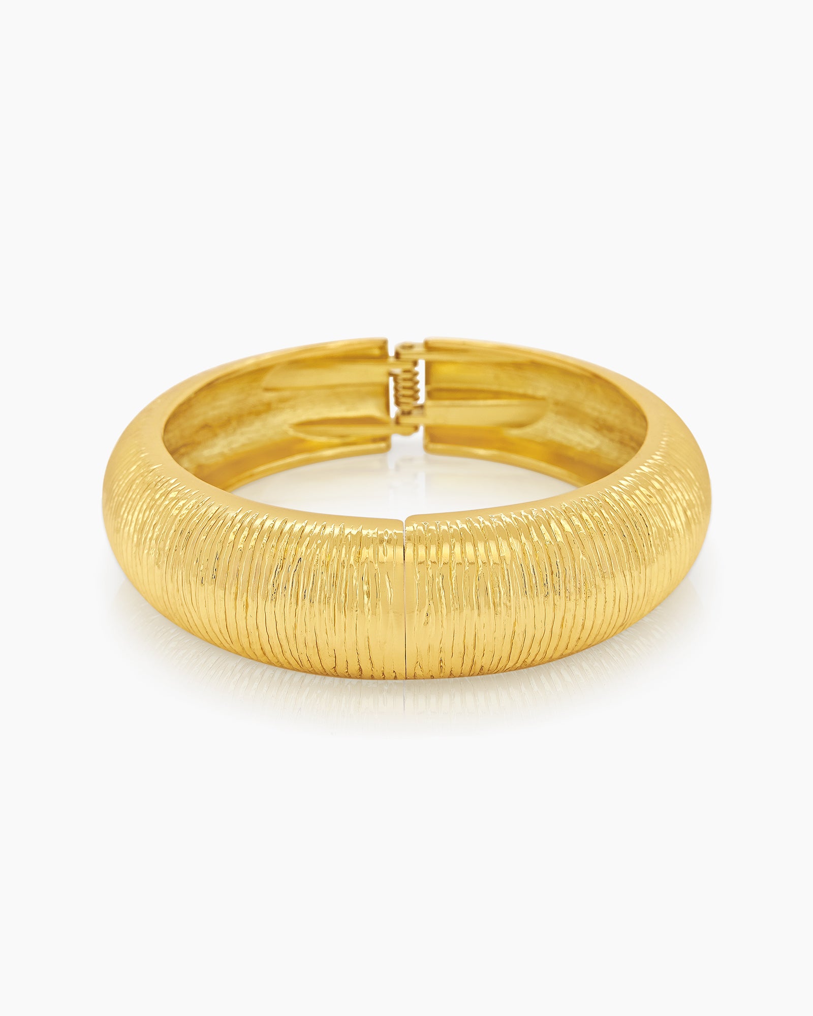 A classic gold bangle with a deeply etched texture, high-shine finish, and a secure hinge clasp