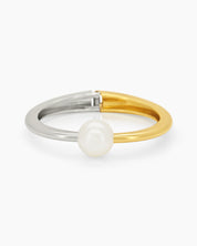 A mixed-metal hinged bangle pairing silver and gold in a seamless line, with a single pearl accent